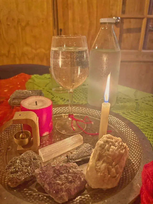 Altar con vela, cristales y un vaso de agua