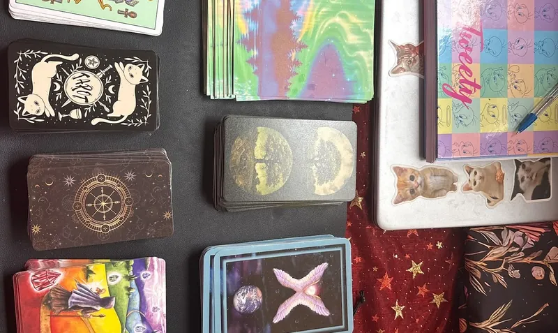 Mazos de tarot y cartas de colores sobre un paño oscuro